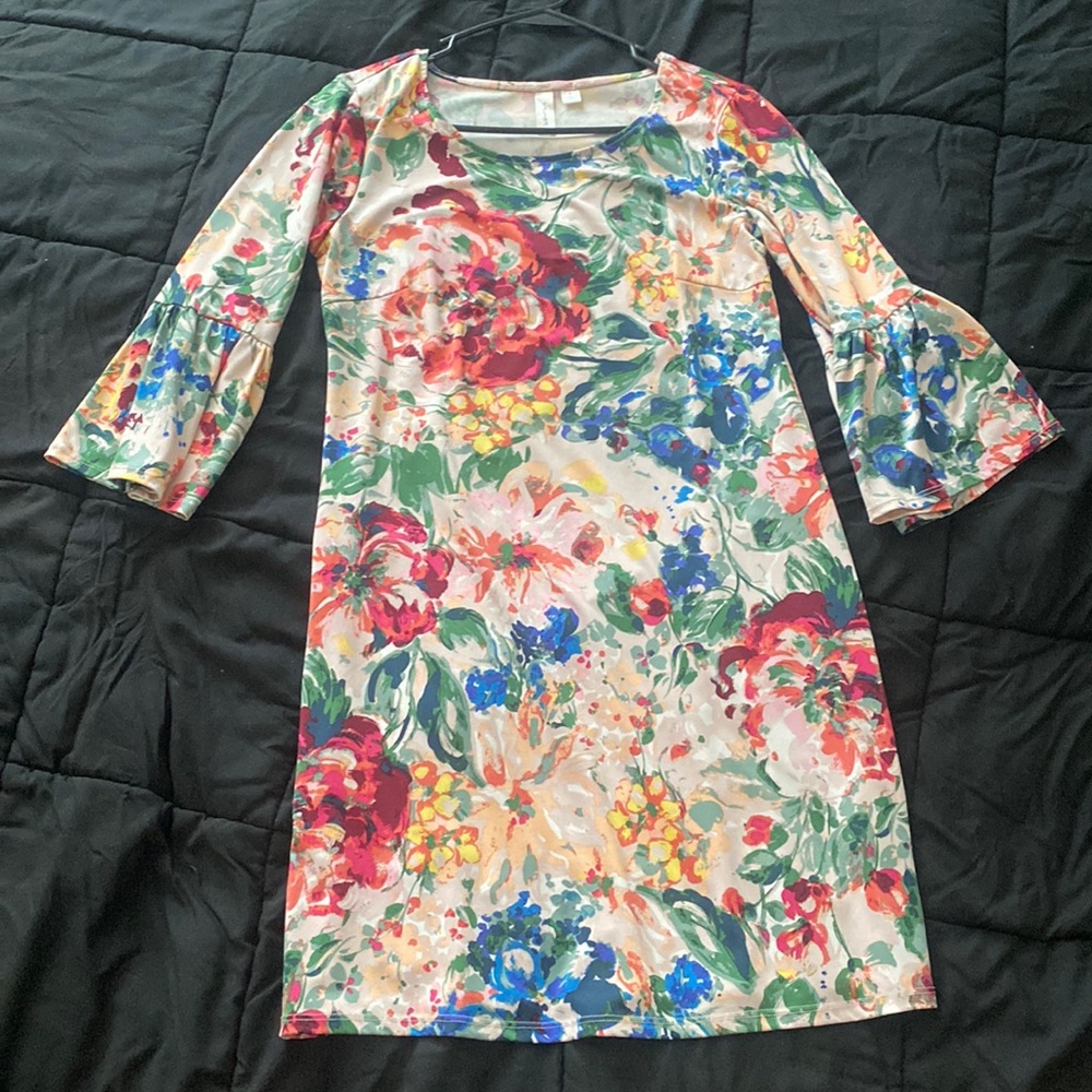 Blush pink dress with floral design. Quarter length, circular flounce sleeves.